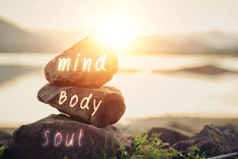 Three rocks on top of each other with mind, body, soul written on each